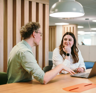 Two people sat at a desk talking