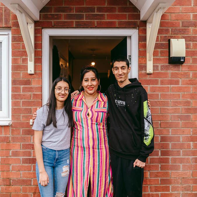 three members of a family outside the front door of their new bromford home