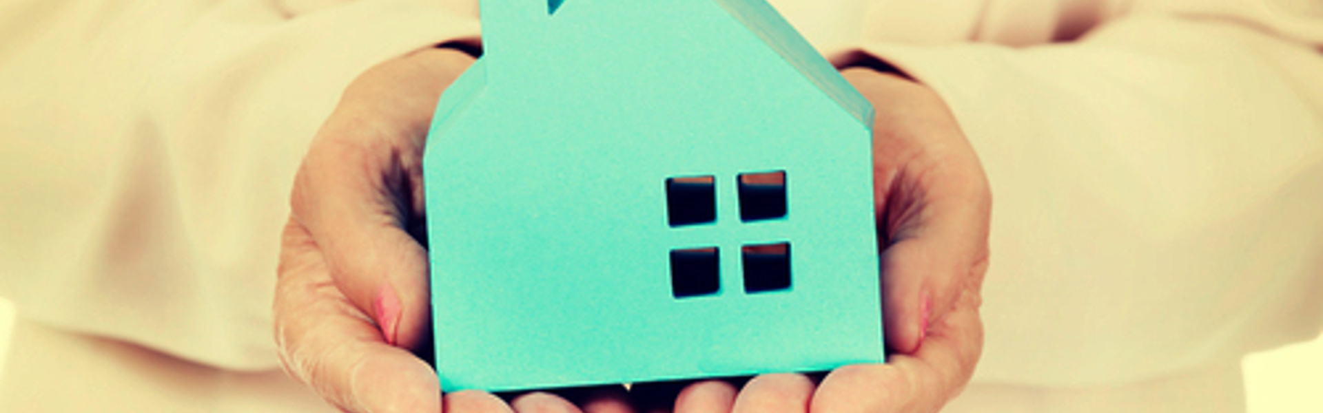 Small blue house being held in a persons hands