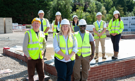 Colleagues on a construction site wearing hard hats and hi vis vests