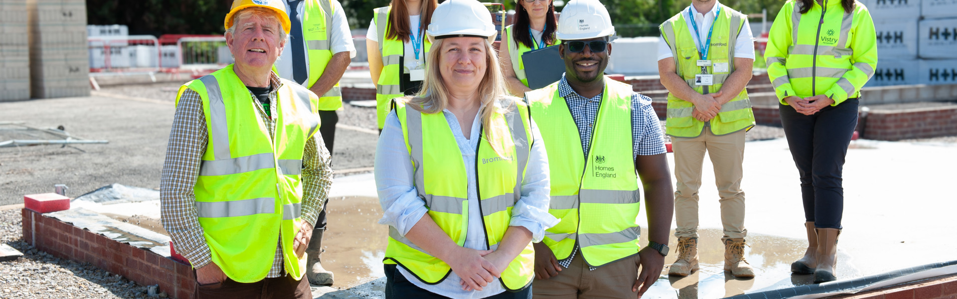 Colleagues on a construction site wearing hard hats and hi vis vests