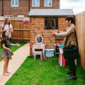 a bromford neighbourhood coach having fun throwing a ball a customer in the garden