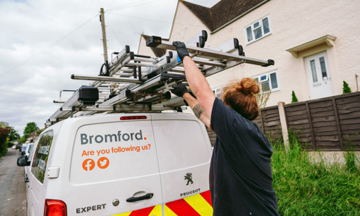 A Bromford colleague taking a ladder from a Bromford van 