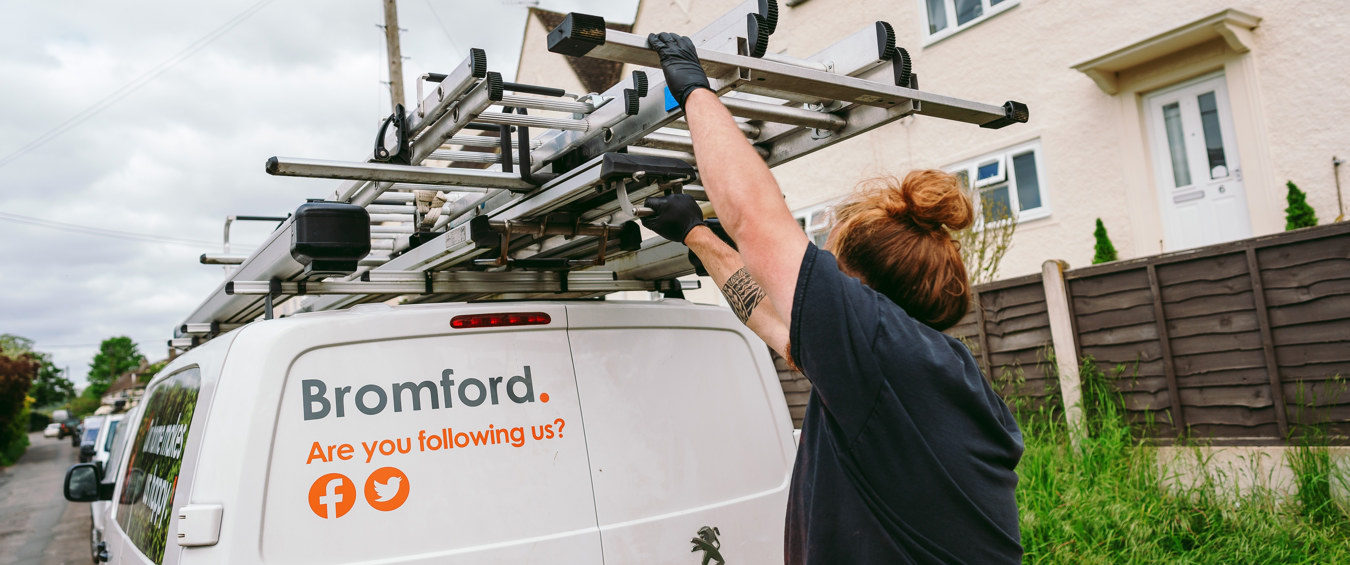 A Bromford colleague taking a ladder from a Bromford van 