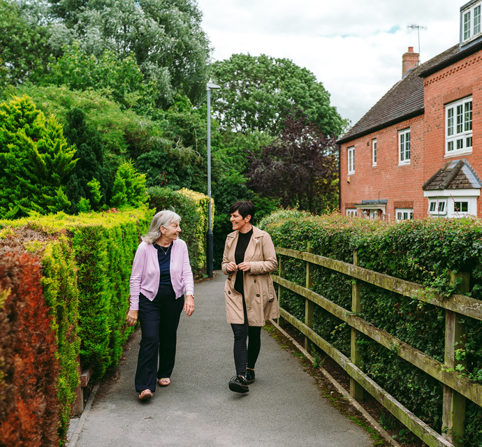 a bromford neighbourhood coach talking to a customer, while walking in their local community