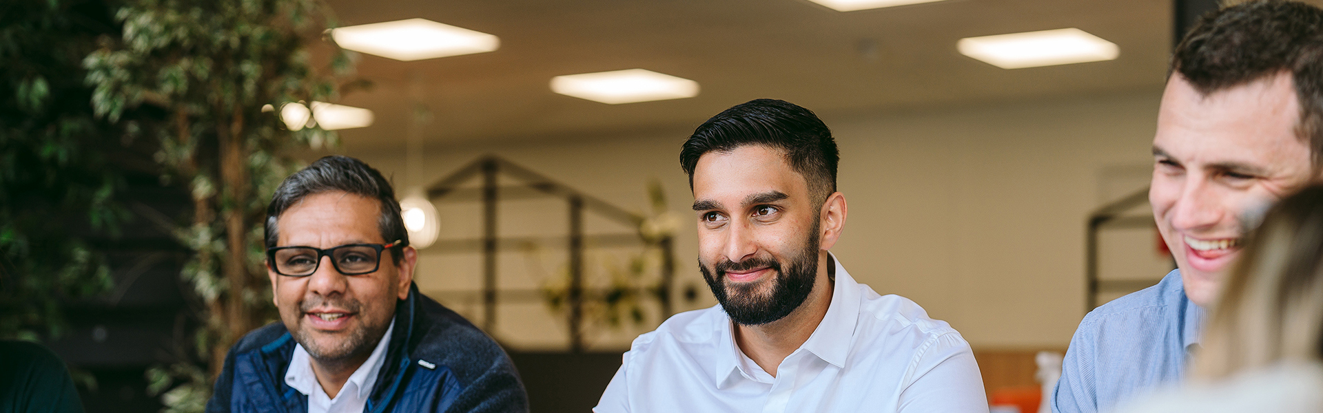 3 bromford colleagues sitting side by side and smiling