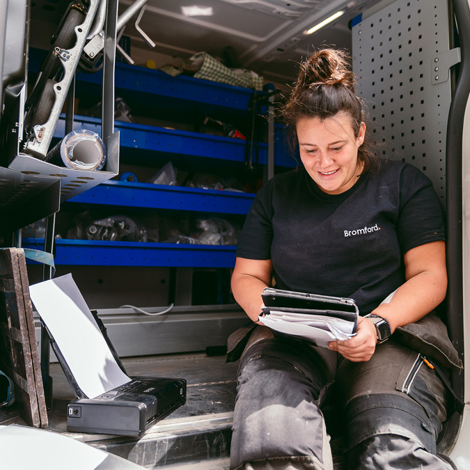 a bromford colleague sitting in a van using a tablet