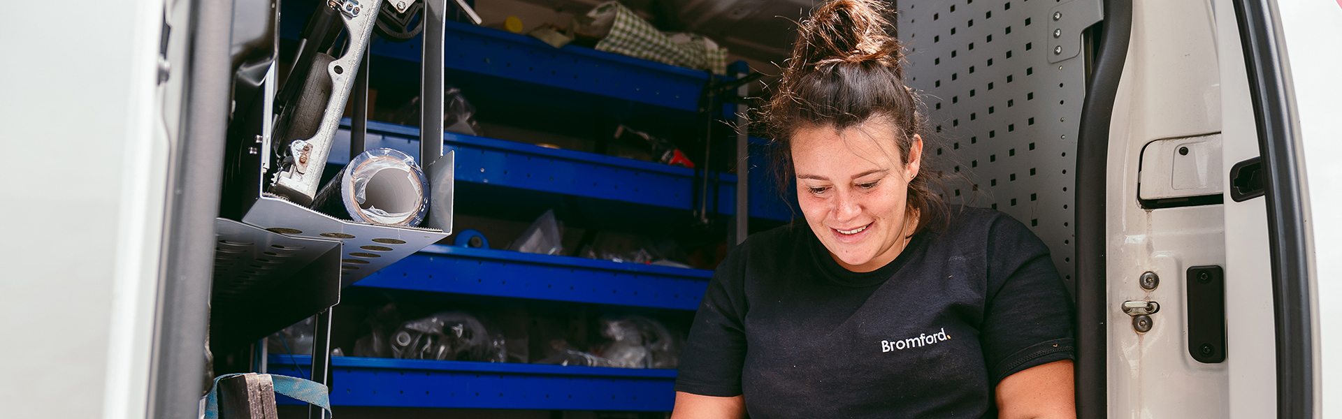 a bromford colleague sitting in a van using a tablet