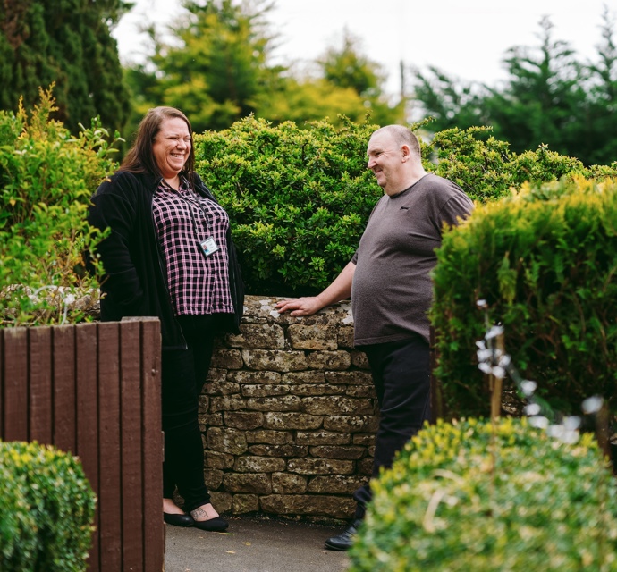 A Bromford neighbourhood coach talking to a male customer in his garden