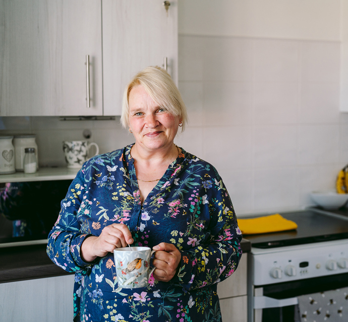 Person holding a mug in their kitchen