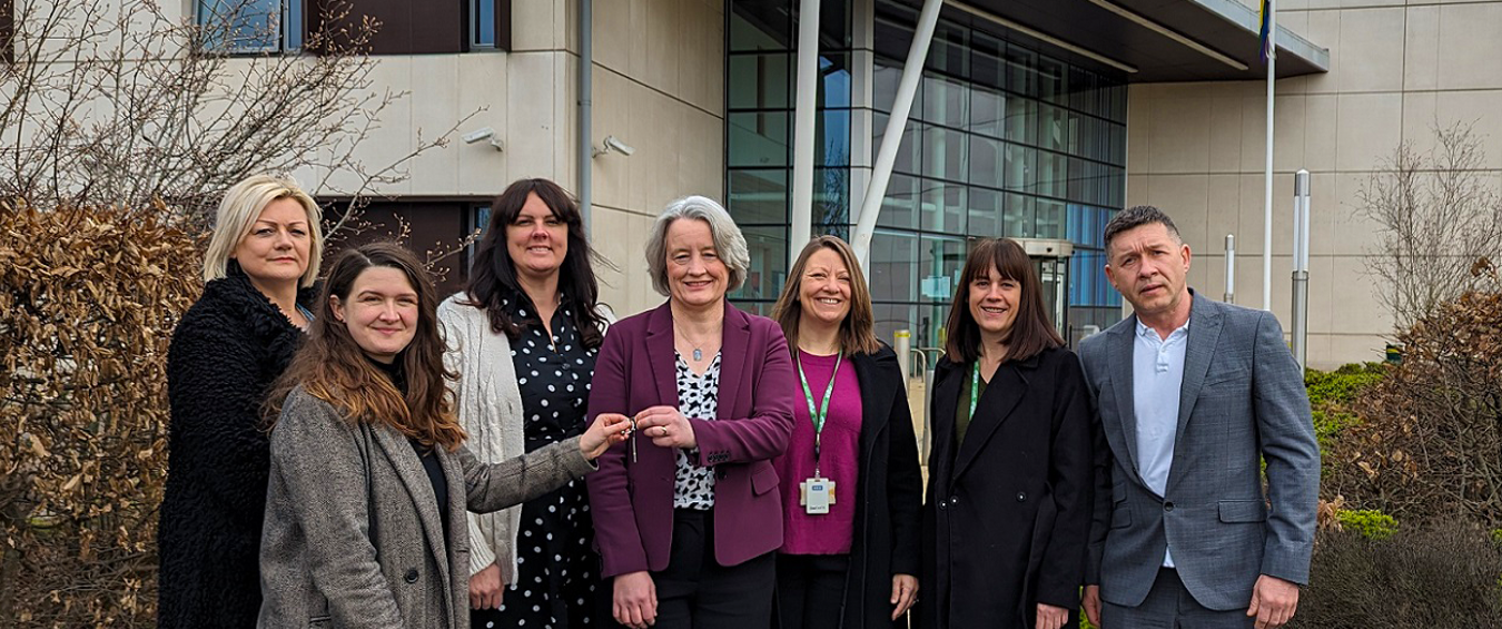 Colleagues standing and holding keys 