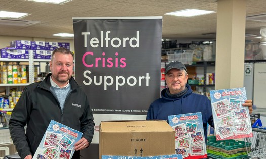 Two people holding advent calendars at Telford foodbank  