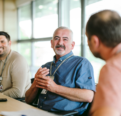 Bromford colleagues sitting  talking in a meeting room