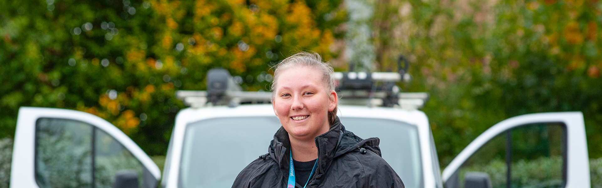 A Bromford colleague stands in front of a van